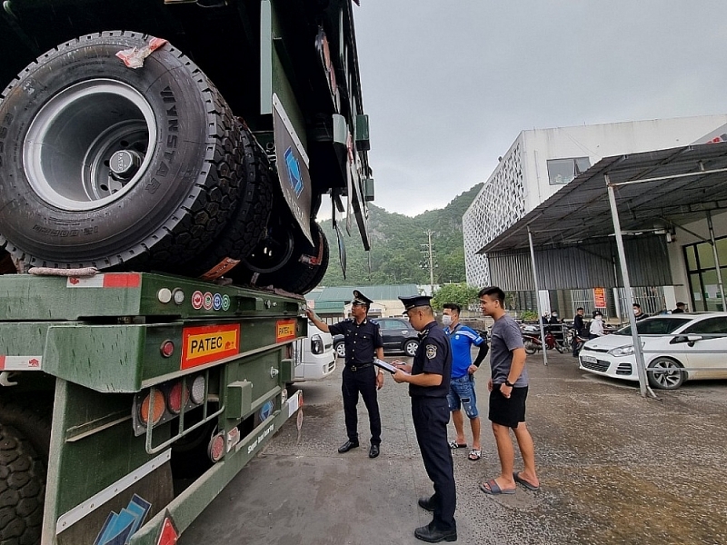 Customs officers inspect imported goods at Huu Nghi border gate area.