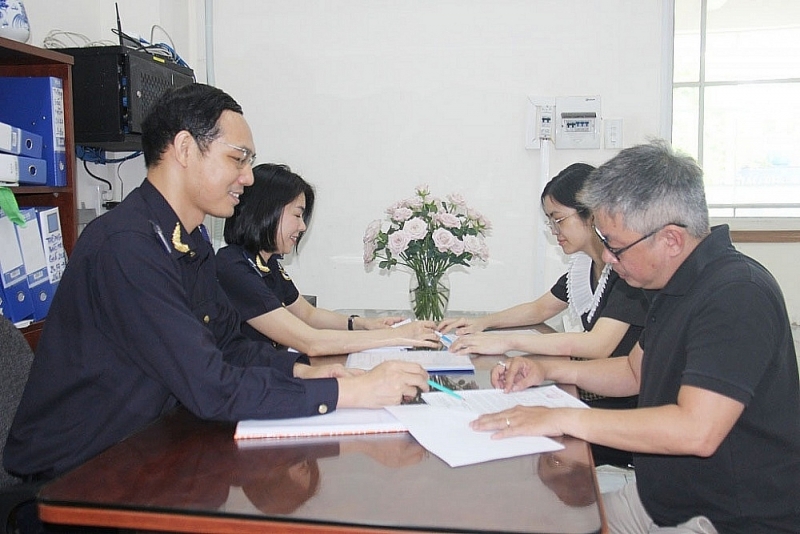 Officials of the Investment Management Customs Branch exchange and guide procedures for enterprises. Photo: T.H  