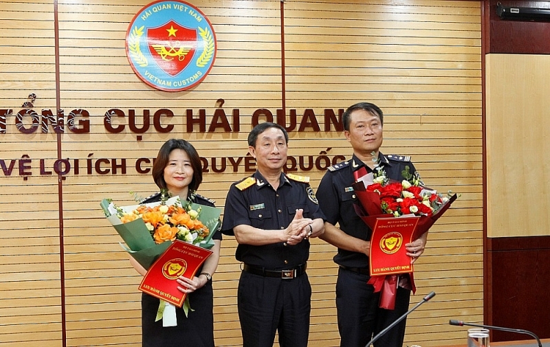 Deputy General Director of General Department of Customs Hoang Viet Cuong hands over the appointment decision and presented flowers to congratulate the two new Deputy Directors. Photo: Q.H