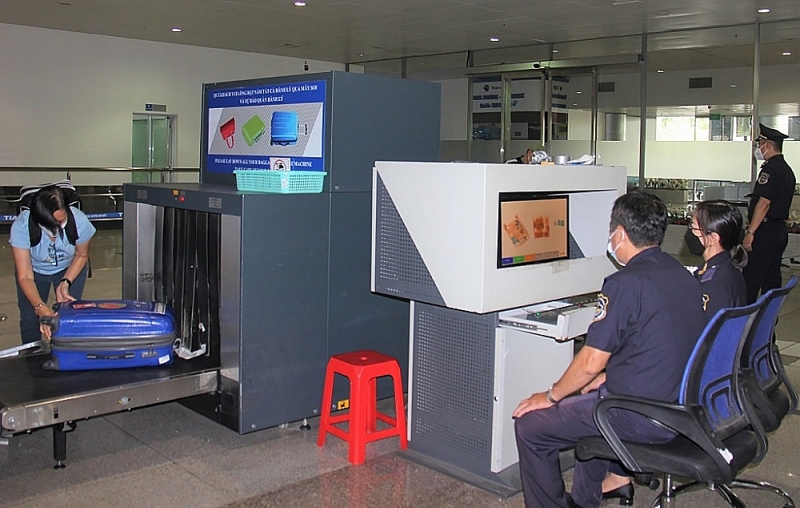 Tan Son Nhat International Airport Customs officers check luggage of incoming passengers. Photo: T.D