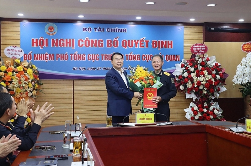 On behalf of the Party Committee and leaders of the Ministry of Finance, Deputy Minister Nguyen Duc Chi presented the Decision and gave flowers to congratulate Deputy Director General Dinh Ngoc Thang. Photo: Ngọc Linh