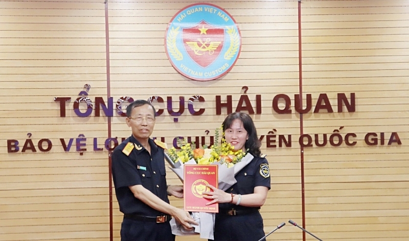 Director General of the General Department of Customs Nguyen Van Can awards the decision and flowers to congratulate the new Director of the Inspectorate Department Pham Thi Thu Huong.