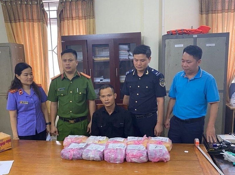 Subject Nguyen Thanh Luan (seated) was arrested by Ha Tinh Customs and Police on May 2, 2023 while driving a motorbike to transport 32,000 ecstasy pills and 800 heroin pills. Photo: Dinh Thong