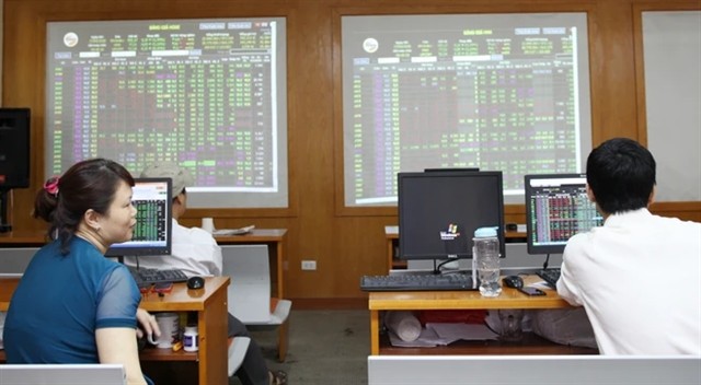 Investors watch the market and conduct transactions on a trading floor of a securities firm in Hanoi (Photo: VNA)