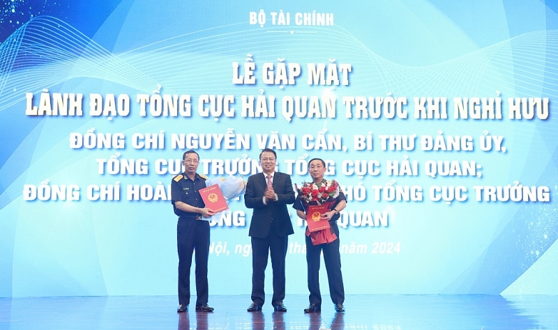 Deputy Minister Nguyen Duc Chi presents decisions and flowers to Director General Nguyen Van Can and Deputy Director General Hoang Viet Cuong. Photo: Quang Hung.