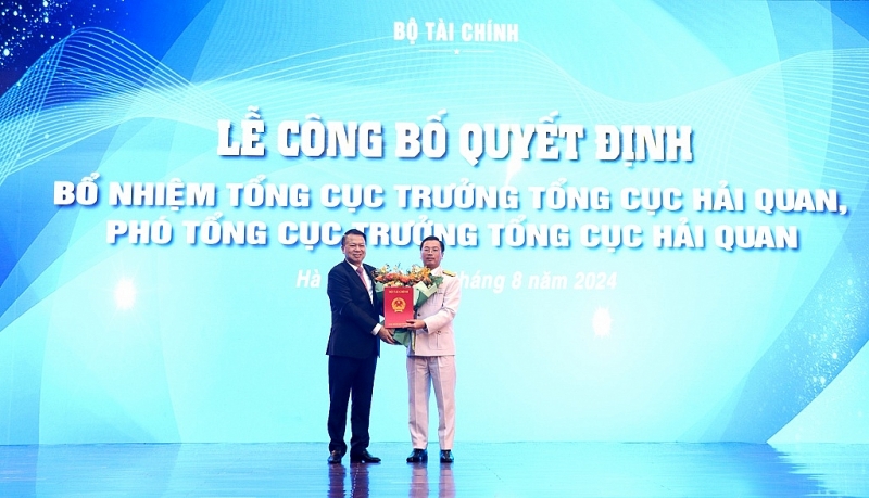 Deputy Minister Nguyen Duc Chi presents the Decision and flowers to congratulate the new Deputy Director GeneralTran Duc Hung. Photo: Quang Hung.