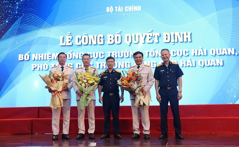 Deputy Director General Luu Manh Tuong (third from right) and Deputy Director General Dinh Ngoc Thang (right) present flowers to congratulate the new leaders of the General Department. Photo: Quang Hung.