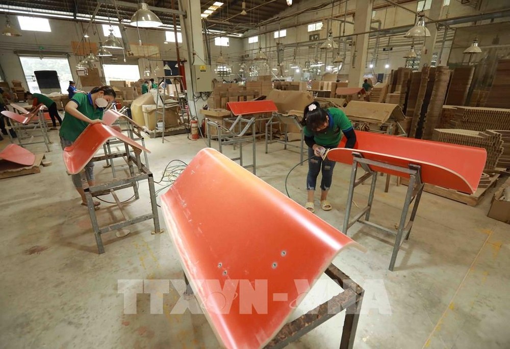 Workers put final touches on wood planks for export at a factory in An Dien commune of Ben Cat district, Binh Duong province. (Photo: VNA)