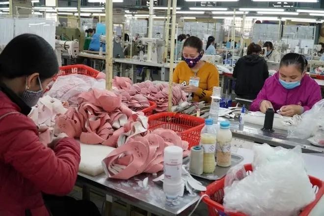 Producing footwear for export (Photo: VNA)