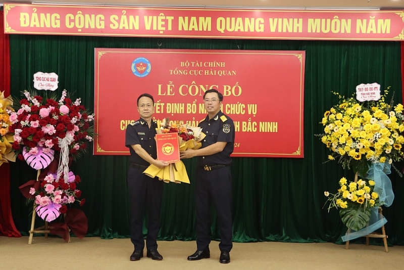 At the ceremony, Deputy Director General of Vietnam Customs Tran Duc Hung presented the decision and flowers to congratulate the new Director of Bac Ninh Customs Department Pham Chi Thanh. Photo: Q.H