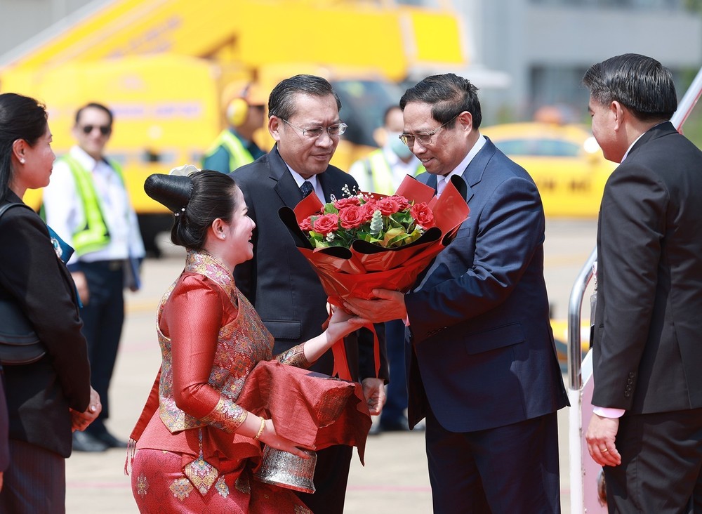 Prime Minister Pham Minh Chinh and his encourage are greeted at the airport by Lao Minister of Energy and Mines Phosay Sayyasone and other Lao officials, along with Vietnamese Ambassador to Laos Nguyen Minh Tam, among other diplomats. (Photo: VNA)