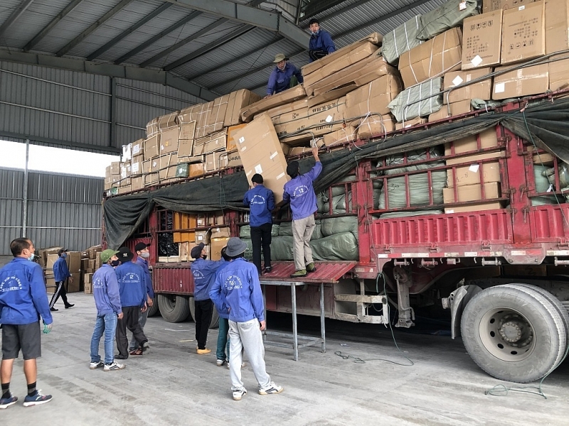 Workers unload goods to be sent via postal and express delivery services at Huu Nghi international border gate. Photo: H.Nu