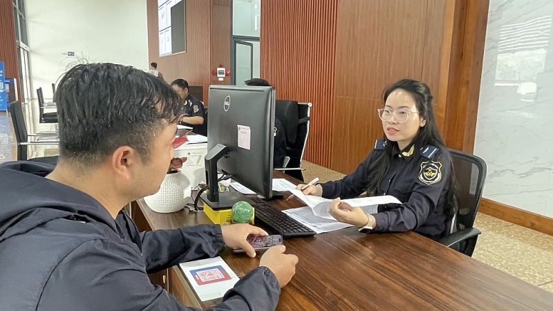 A civil servant of the Lao Cai Border Gate Customs Branch guides businesses to scan the Branch's QR code. Photo: Ngoc Linh