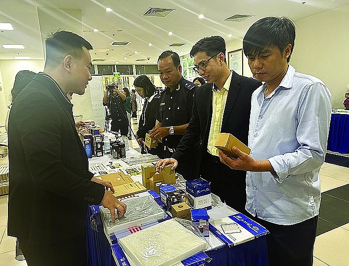 Enterprises guide delegates to distinguish genuine and fake goods at the Dialogue on December 6, 2024. Photo: T.H