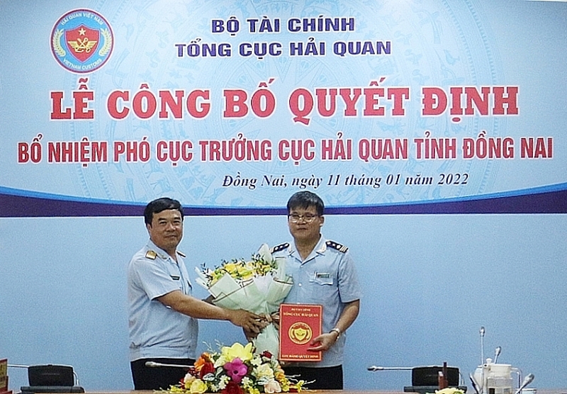 Deputy Director General of Vietnam Customs Nguyen Van Tho awards the appointment decision and flowers to Le Thanh Van. Photo: N.H