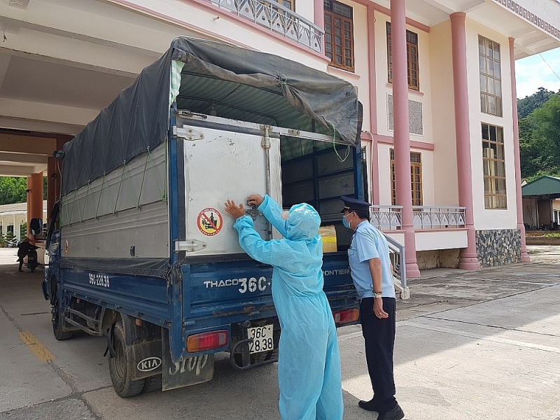 Customs officers of Na Meo international border gate Customs Branch (Thanh Hoa) take anti-pandemic measures during the physical inspection of goods.