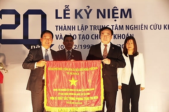 Mr. Tran Van Dung, Chairman of the State Securities Commission awards the Government's emulation flag to the leading representative of the Securities Research and Training Center.