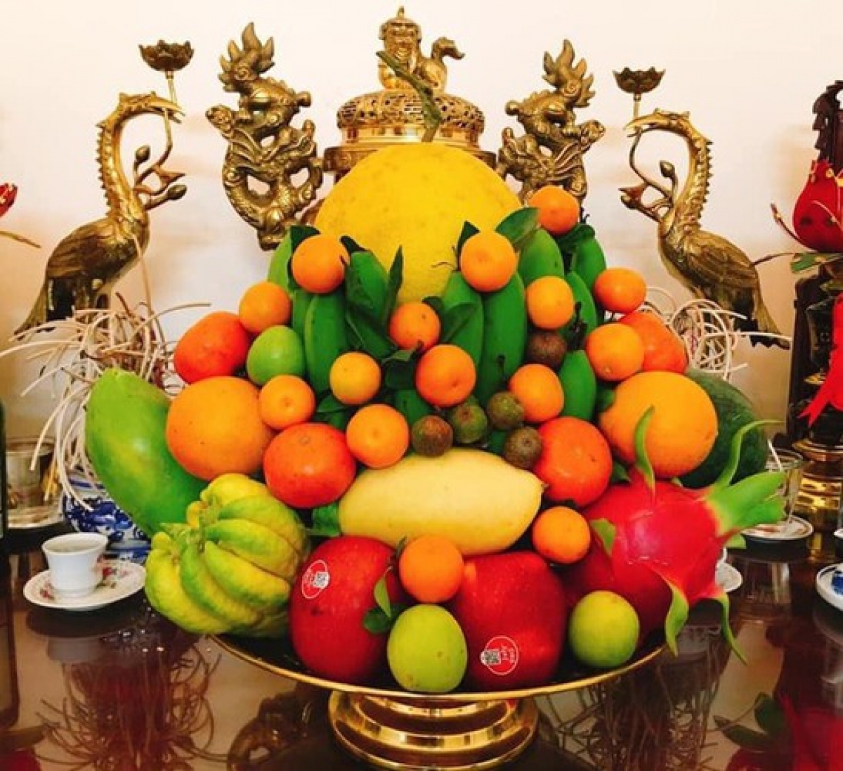 Arranging a five-fruit tray and placing it upon family alters is a Vietnamese custom that takes place during Tet as a sign of respect and gratitude to ancestors. In northern Vietnam the tray will often include bananas, pomelos, peaches, kumquats, and persimmons. In contrast, trays in the south will include custard apples, coconuts, papayas, mangos, and figs, symbolising the wishes of southerners of “just enough to spend”.