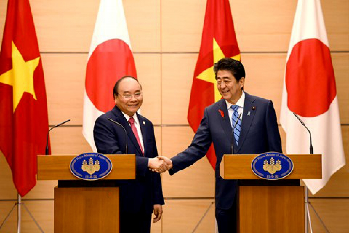 Vietnamese PM Nguyen Xuan Phuc (L) shakes hand with Japanese PM Shinzo Abe during his trip to Tokyo in October 8, 2018