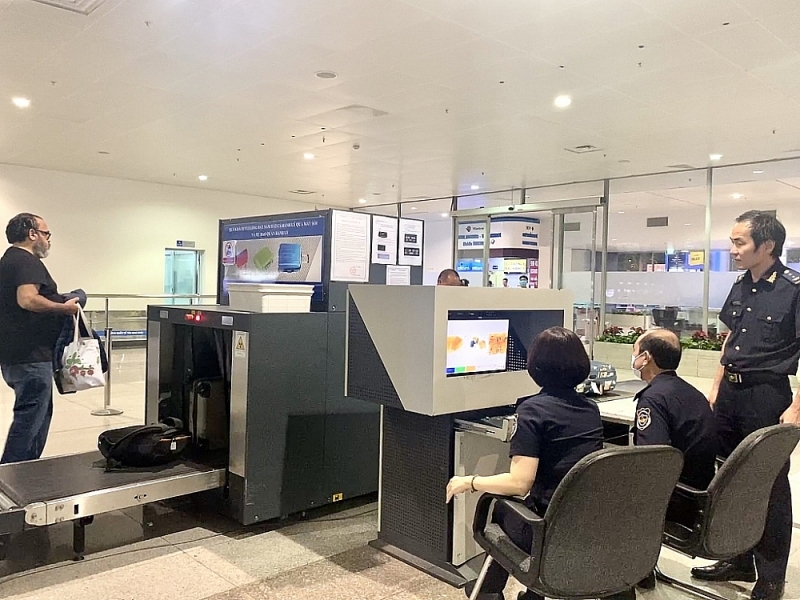 Officials of the Entry Luggage Customs Procedure Team, Tan Son Nhat International Airport Customs Branch check baggage through a scanning machine. Photo: T.Dịu