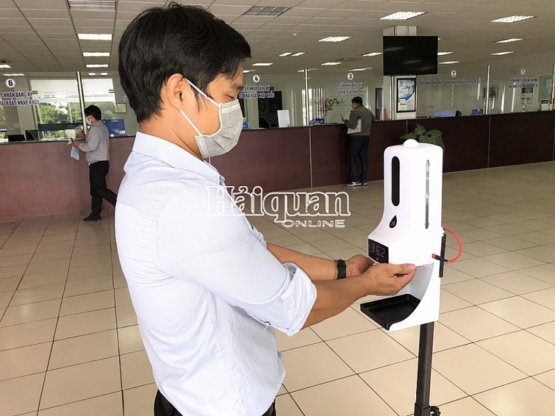 Enterprises measure body temperature before carrying out procedures at Thu Dau Mot Customs Branch. Photo: T.Dịu