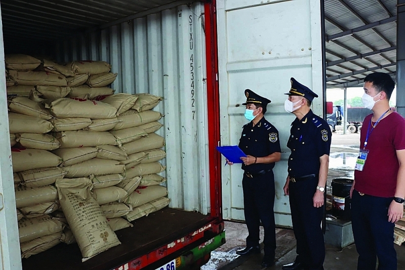Mong Cai Customs officer checks exported goods through Bac Luan II Bridge. Photo: Q.H