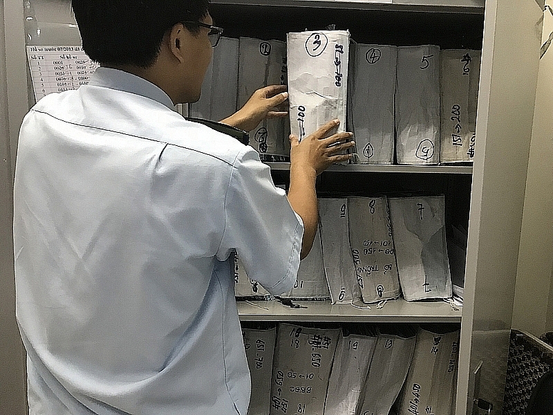 HCM City Customs official inspects dossier of enterprise owing tax debt. Photo: T.H