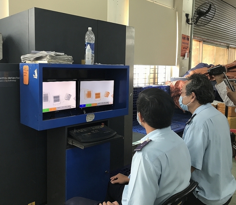 Customs officers of Customs Sub-department for express delivery check imported goods via scanners. Photo: T.H