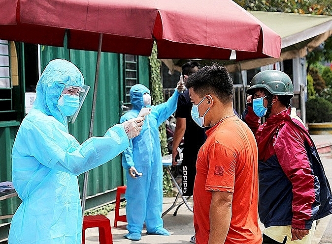 Medical staff check the driver's body temperature at the medical quarantine checkpoint before entering the parking lot at Huu Nghi International Border Gate. Photo: Trí Dũng
