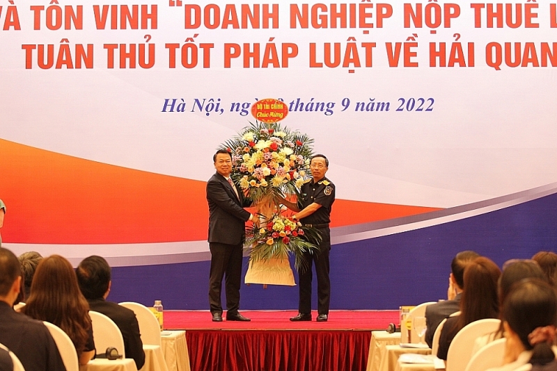 Director General of Vietnam Customs Nguyen Van Can received flower from Deputy Finance Minister Nguyen Duc Chi. Photo: Thái Bình
